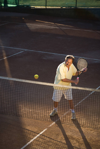 Senior man playing tennis - Фото, изображение