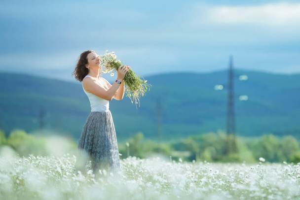 The woman in the agricultural field with white daisies - Foto, immagini