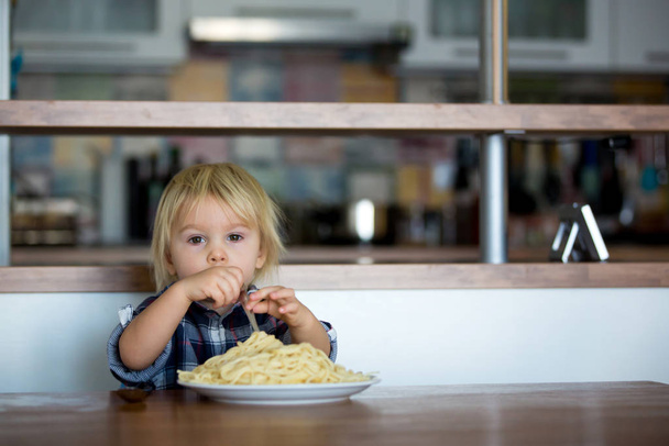 Little baby boy, toddler child, eating spaghetti for lunch and m - Foto, Bild