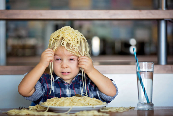 Little baby boy, toddler child, eating spaghetti for lunch and m - Фото, изображение