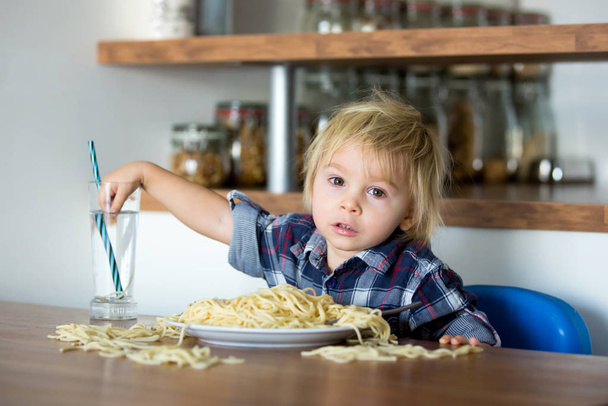 Little baby boy, toddler child, eating spaghetti for lunch and m - Foto, afbeelding