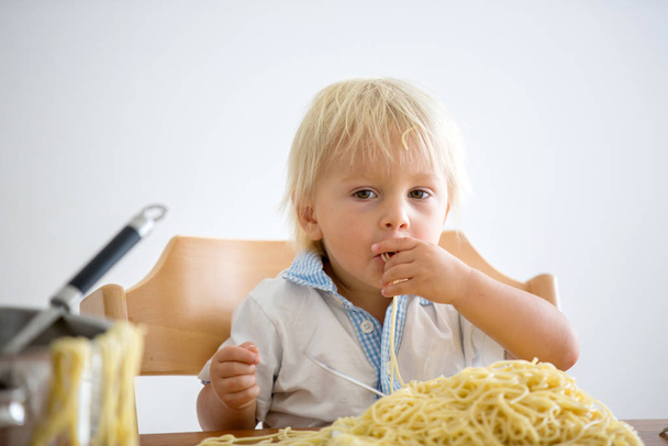 Little baby boy, toddler child, eating spaghetti for lunch and m - Zdjęcie, obraz