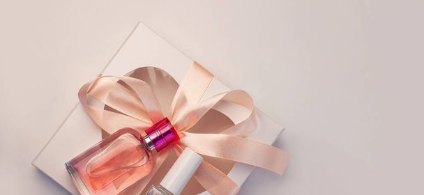 San Valentín concepto creativo flatlay.Gift caja maqueta, botella de perfume rosa, esmalte de uñas con cinta sobre fondo blanco
 - Foto, imagen