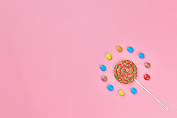 Sweet lollipop and candy on pink background - Foto, afbeelding