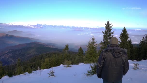 Az ember a téli tájat figyeli a hegyen. - Felvétel, videó