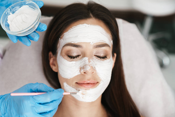 Photo of attractive adult woman getting cosmetic procedure - Foto, afbeelding