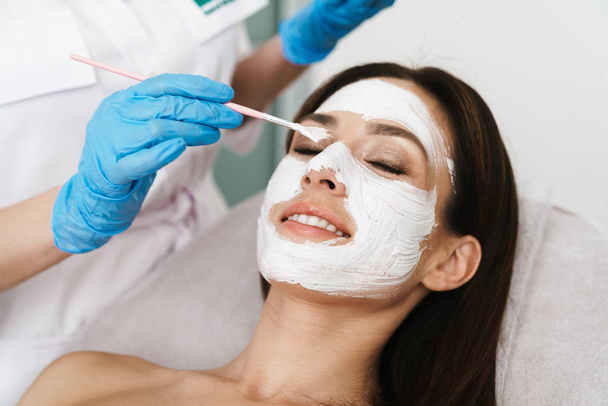 Photo of attractive smiling woman getting cosmetic procedure - Foto, Imagem