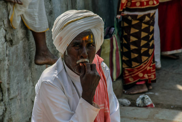 Imagem de um velho homem sozinho vestindo turbante branco ajustando-se em starers de um templo hindu
 - Foto, Imagem