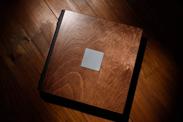 Livre photo dans une couverture en bois sur une table en bois. Lumière dure
 - Photo, image