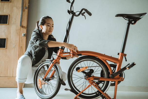 young entrepreneur woman prepares a folding bike from her home - Foto, immagini