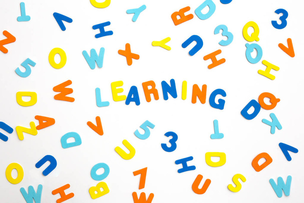 Kolorowe litery i słowo "uczenie się na białym tle", koncepcja uczenia się lub nauki - Zdjęcie, obraz