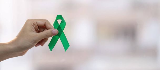 Man holding green Ribbon for supporting people living and illnes - Foto, afbeelding