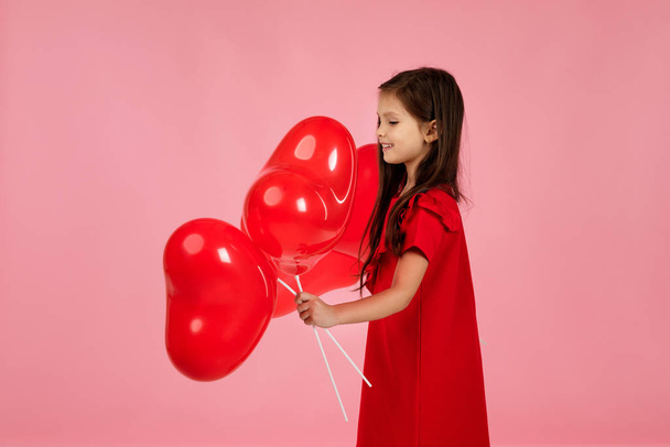 child girl holding red heart shaped balloon - Фото, изображение