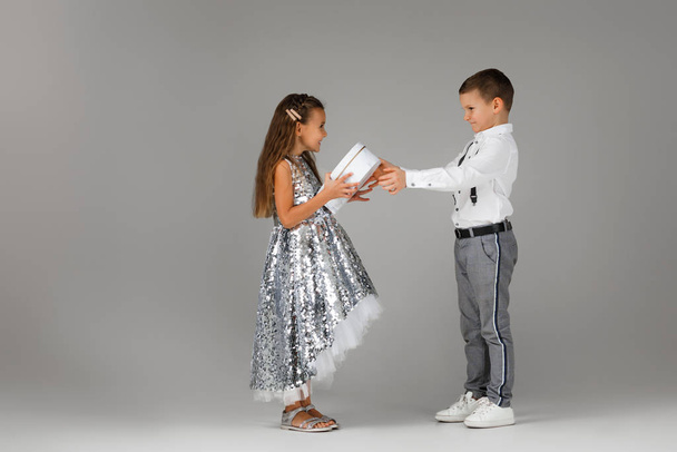 little boy giving gift box to fashionable child girl - Zdjęcie, obraz