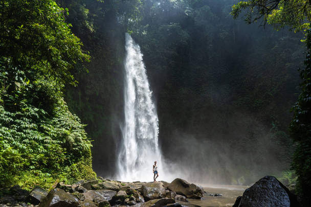 Abenteuerlustige stehen in der Nähe des wunderschönen Dschungel-Wasserfalls und - Foto, Bild