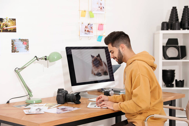 Professional photographer working at table in office - Photo, image