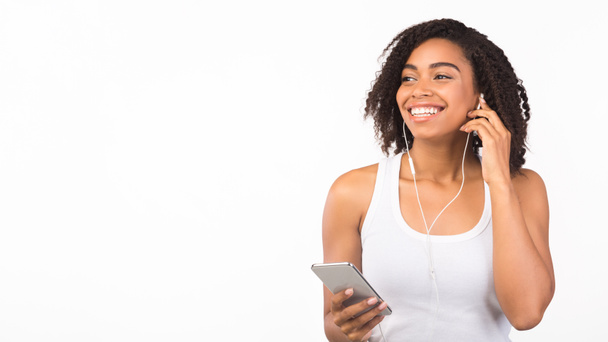 Portret uśmiechniętej czarnej dziewczyny słuchającej muzyki - Zdjęcie, obraz