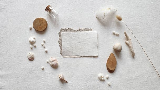 Blank white Wedding invitation card mockup craft envelope, textured table background. Tropical Sea shell, corals, light stone, wooden slice, paper sheet. Template. Vacation memories Flat lay, top view - Fotó, kép