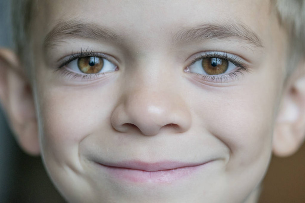 Malý chlapec s úsměvem pózuje do kamery - Fotografie, Obrázek