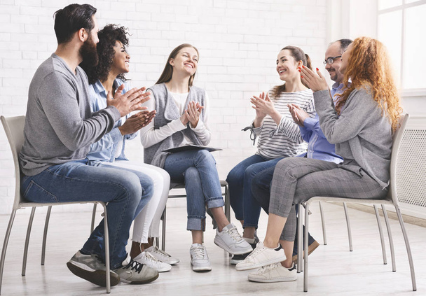 Gruppe glücklicher Menschen, die sich bei einer Therapiesitzung selbst applaudieren und Fortschritte feiern - Foto, Bild