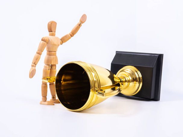 Drewniana figurka zabawki i złoty puchar trofeum na białym tle - Zdjęcie, obraz