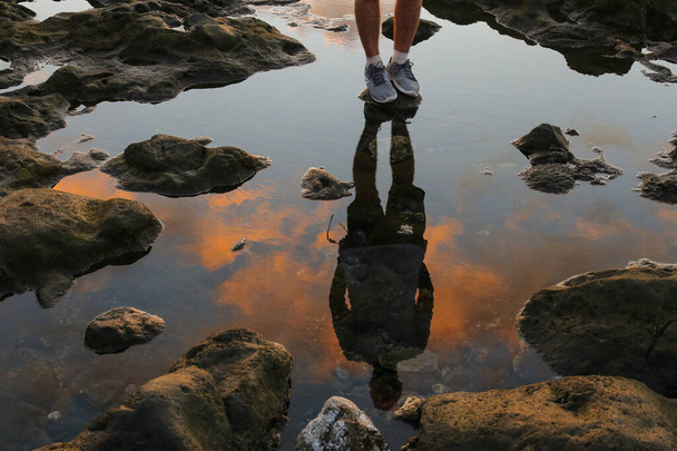 Отражение в воде человека, стоящего на берегу моря
 - Фото, изображение