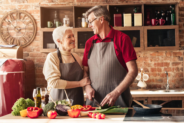 Onnellinen vanhempi mies ja nainen ruoanlaitto terveellistä lounasta keittiössä
 - Valokuva, kuva