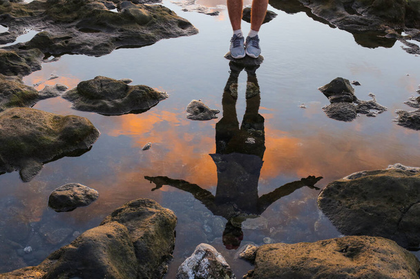 Роздуми у воді чоловіка, що стоїть на березі моря
 - Фото, зображення