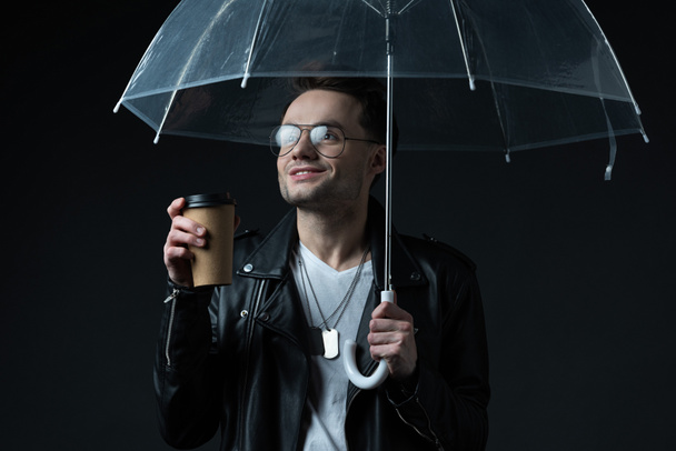 mosolygós stílusos brutális férfi motoros kabát esernyő és kávé, hogy menjen elszigetelt fekete - Fotó, kép