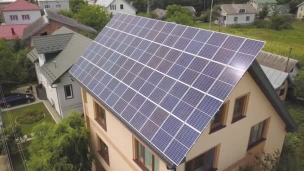 Letecký pohled na nový moderní obytný dům s modrým lesklým solárním fotovoltaickým panelem na střeše. Koncept ekologické výroby zelené energie z obnovitelných zdrojů. - Záběry, video