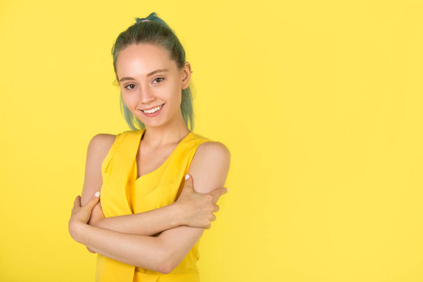 beautiful young woman in a yellow dress on a yellow background - Фото, зображення