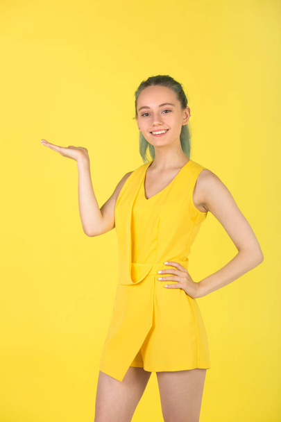 beautiful young woman in a yellow dress on a yellow background - Zdjęcie, obraz