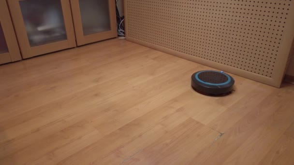 Robot vacuum cleaner rolls around the house, cleaning the house using electronics - Footage, Video