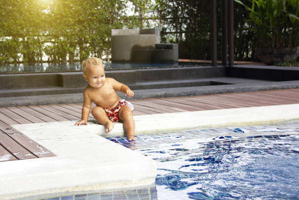 Baby sits near swimming pool - Foto, Imagem