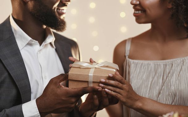 Primer plano de tipo negro dando regalo a su novia
 - Foto, Imagen