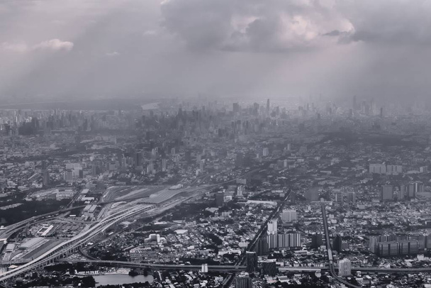 Vista aérea de Bangkok, Tailandia, aire contaminado sobre el horizonte. Urbano en expansión, metrópolis. Color blanco y negro tonificado efecto vintage
. - Foto, Imagen