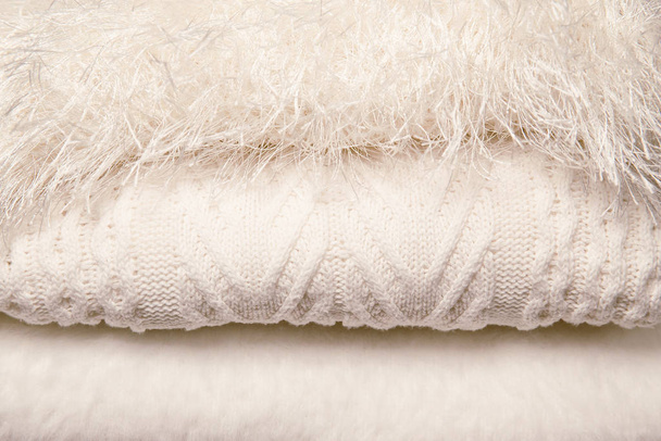 Hromada bílých pletených svetrů. Podzimní a zimní sezóna pletená - Fotografie, Obrázek