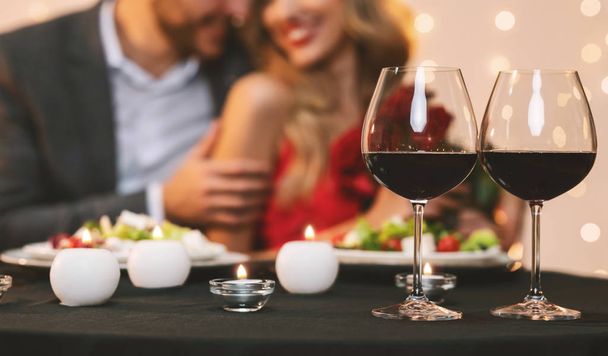 Pár élvezi romantikus vacsora étteremben, szelektív összpontosítás boros poharak - Fotó, kép