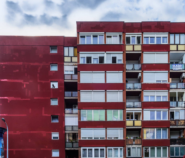 Budapest, Hongrie, août 2019, vue sur la partie supérieure d'un immeuble d'habitation à loyer modique de couleur rouge - Photo, image
