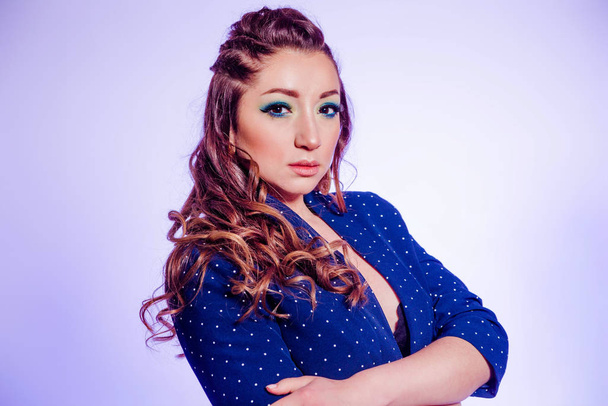 Piękna brunetka z makijażem w niebieskich odcieniach, warkoczach i niebieskiej kurtce na tle fioletowego - Zdjęcie, obraz