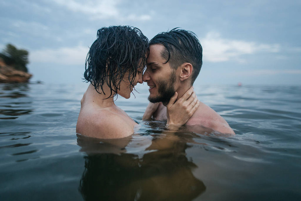 Couple cuddling in the sea - Photo, Image