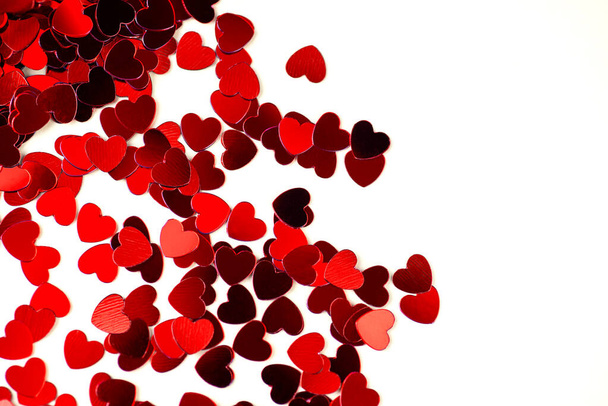 Red hearts are scattered on a bright background. Valentine's Day concept. - 写真・画像