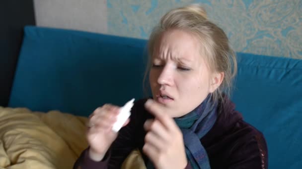 girl squirting her nose medicine very emotional - Materiał filmowy, wideo