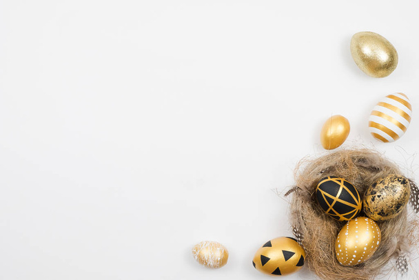 Easter golden decorated eggs in nest isolated on white background for web banner. Minimal easter concept. Happy Easter card with copy space for text. Top view, flatlay. - Foto, Imagem