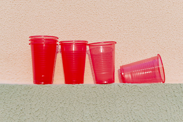 Red plastic cups are on the wall of the house - Foto, imagen