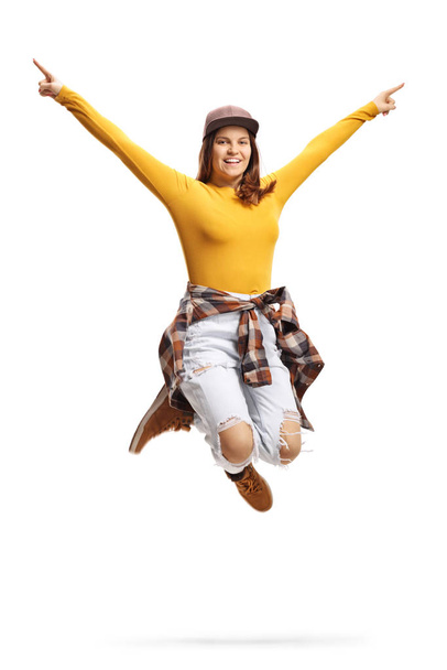 Young female in casual clothes with a cap jumping - Фото, изображение