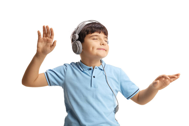 Cute little boy dancing with closed eyes and listening to music  - Фото, зображення