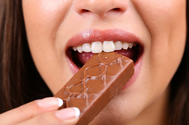 Closeup of woman eating chocolate - Fotoğraf, Görsel