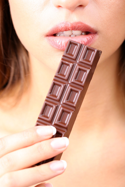 Closeup of woman eating chocolate - Fotoğraf, Görsel