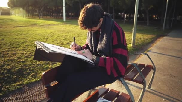 Nowoczesny młody stylowy malarz malarz rysunek szkice w parku - Materiał filmowy, wideo
